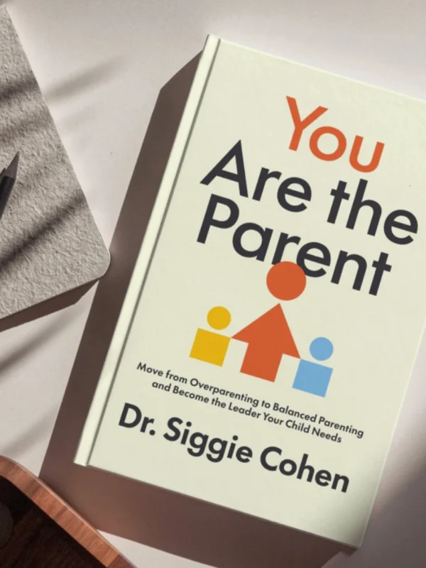 You Are The Parent by Dr. Siggie Cohen, laid flat on a bright surface alongside a notebook and pencil