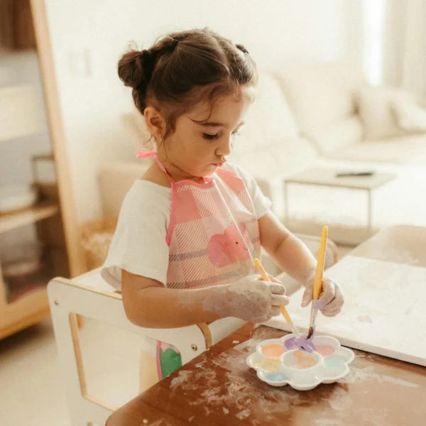Young child painting independently at a table, an example of child-led play and autonomy in children