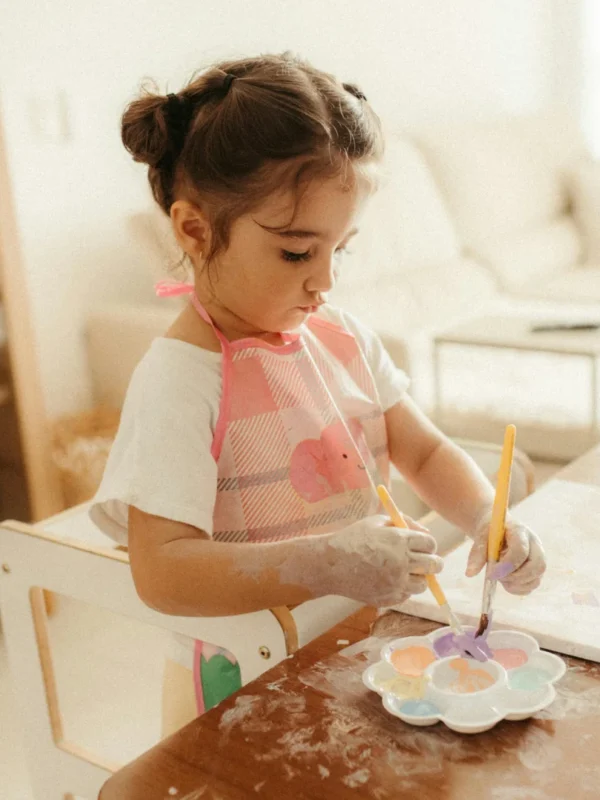 Young child painting independently at a table, an example of child-led play and autonomy in children