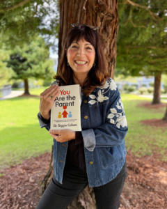 Dr. Siggie Cohen holding her new parenting book, You Are the Parent